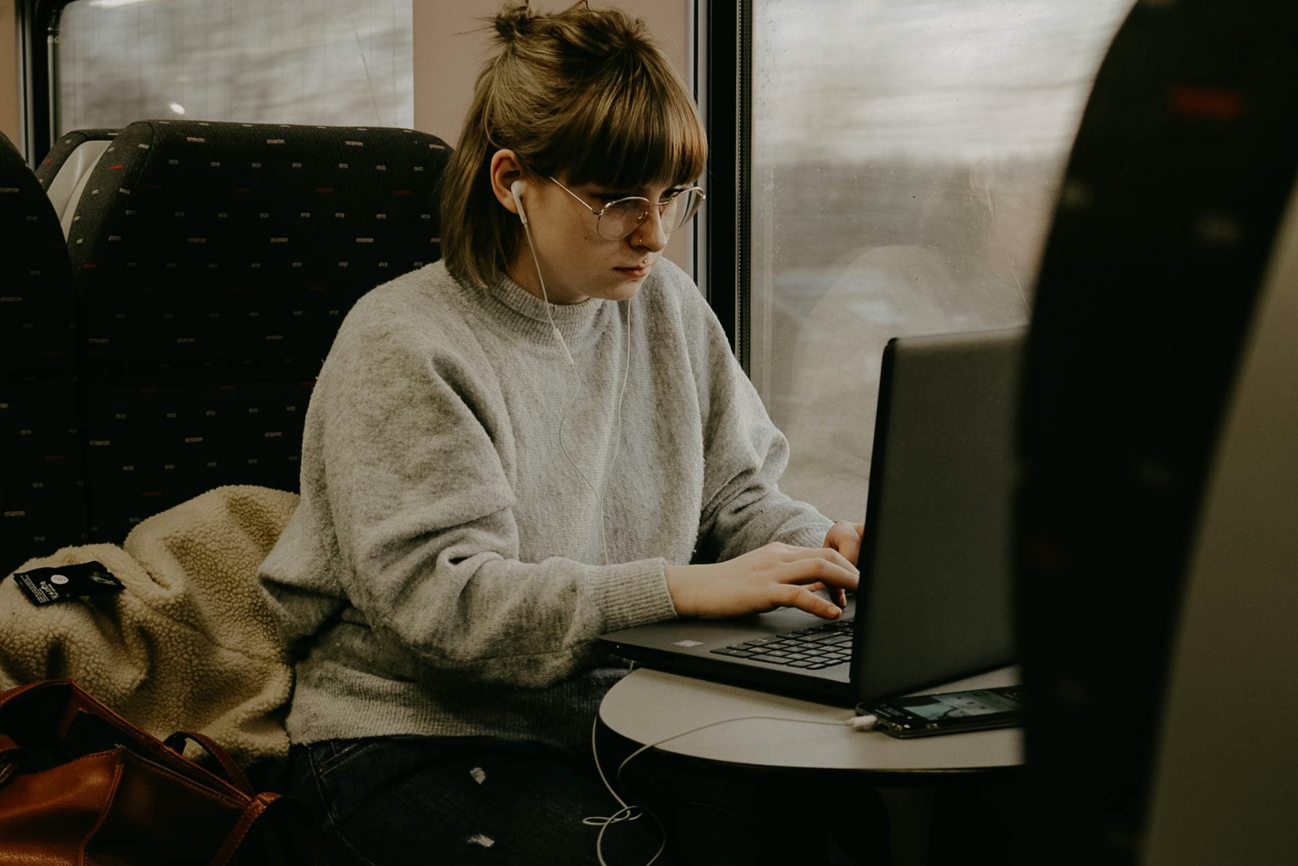 woman on a train looking at a laptop