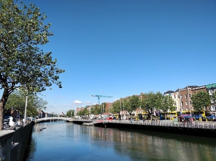 bridge and buildings over water and blue sky