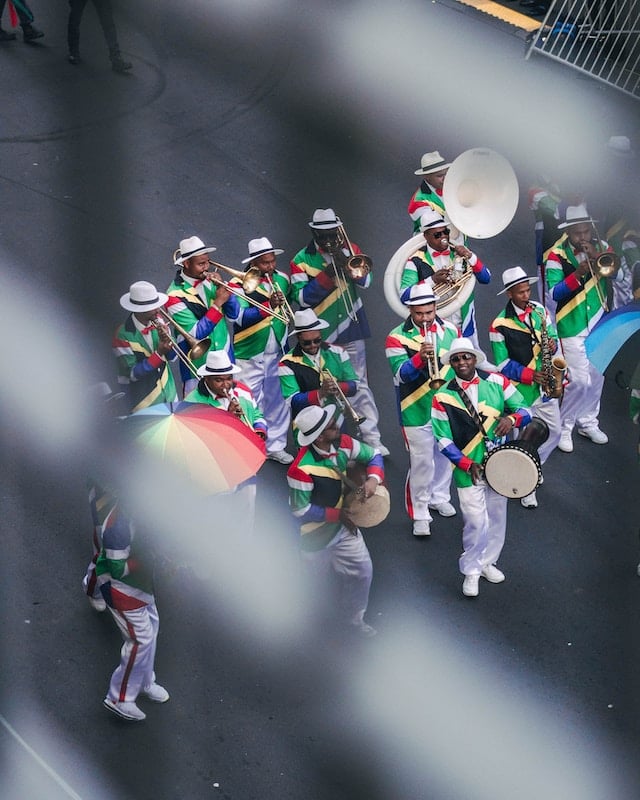 Men wearing South African flag colours, playing instruments in the street