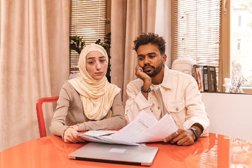 Couple at table, reviewing documents