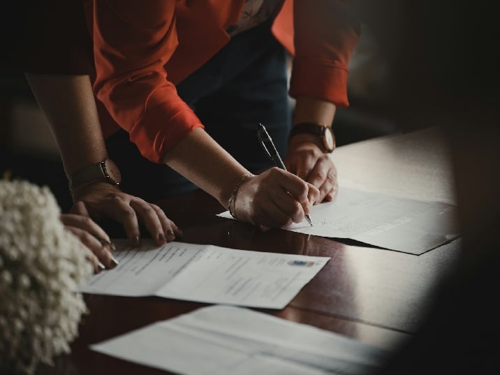Two people filling out identification application forms